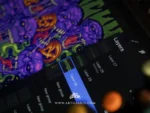 the halloween artwork on a tablet with digital layers and a blurred finger.